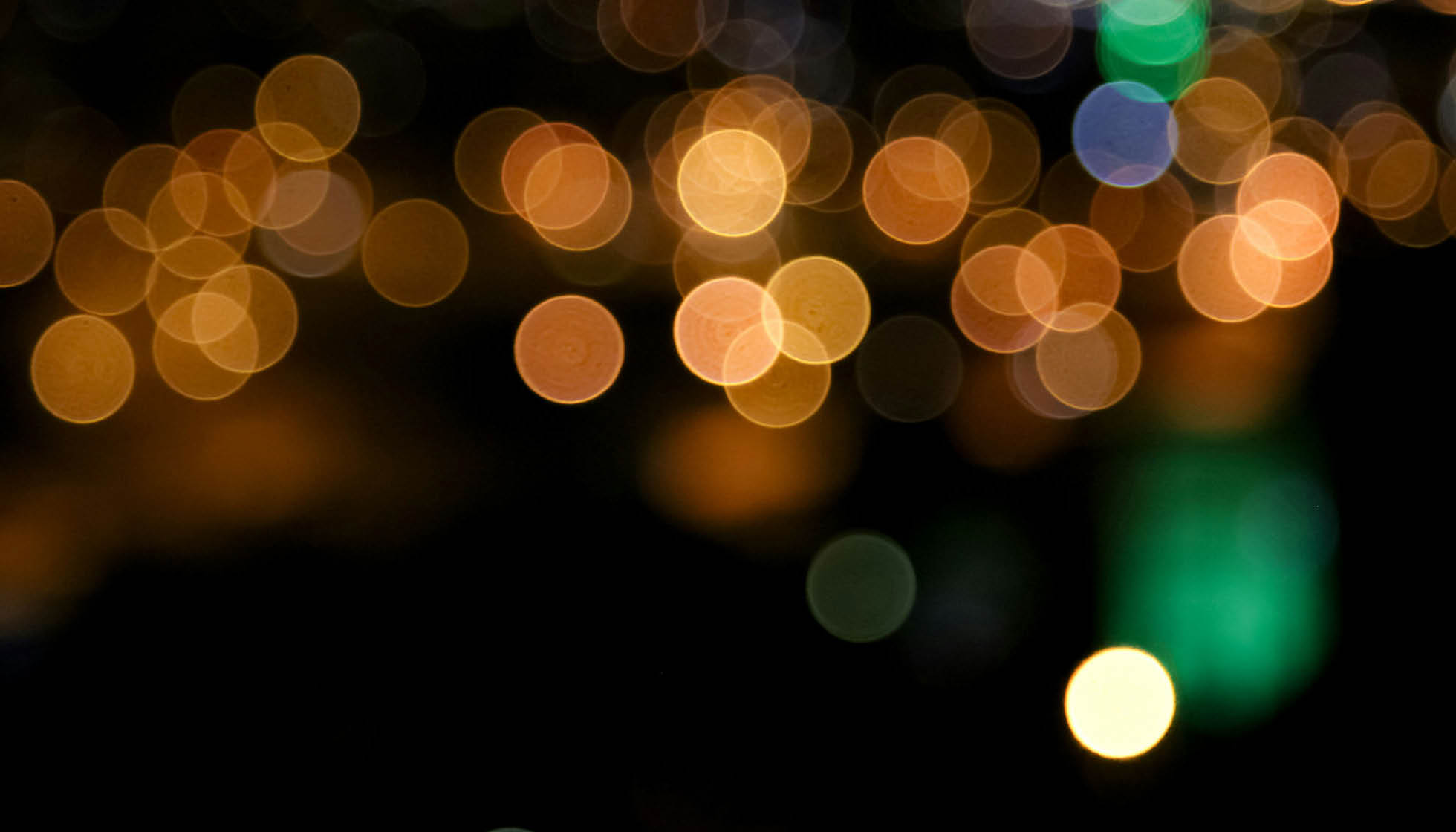 Out-of-focus colorful lights create a bokeh effect against a dark background. Description generated by AI