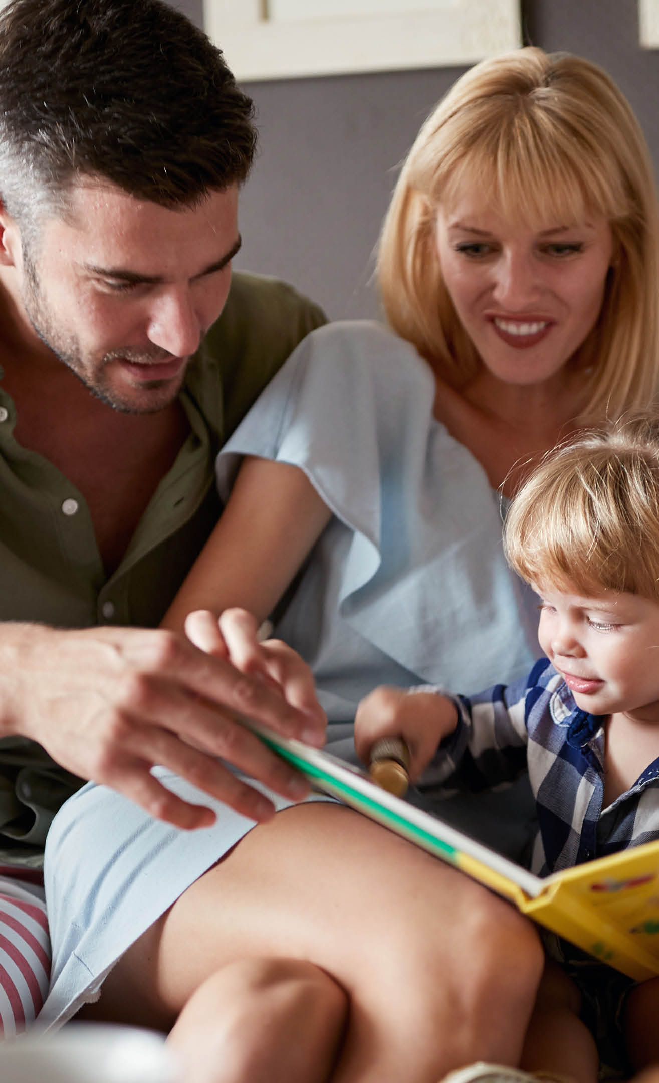 A family sitting on a couch with a boy and a girl. Description generated by AI